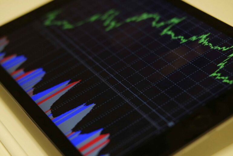 Graph showing stock market data with fluctuating green lines and colorful bar charts, representing options trading for beginners on a digital screen.