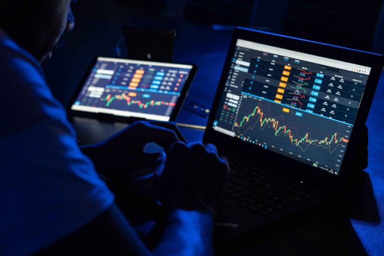 A trader analyzing cryptocurrency charts on multiple screens, displaying price movements and market trends. Ideal for illustrating crypto exchanges in USA.