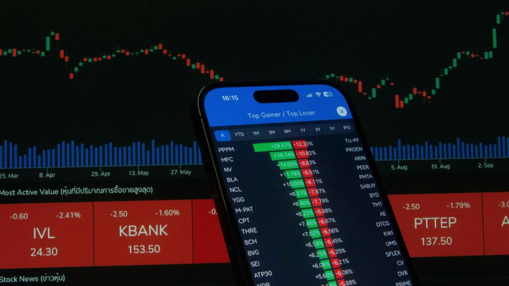  a smartphone with a list of top gainers and losers in a trading app, set against a background of stock charts, symbolizing leverage in trading.